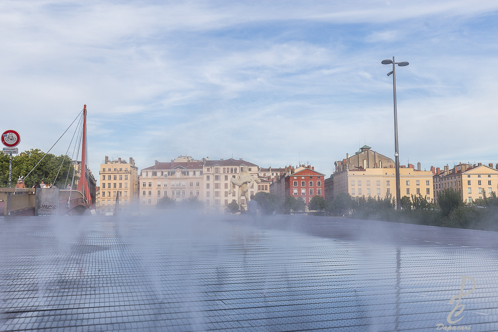 photo en face du palais de justice de Lyon les jets d'eaux sorte avec reflets au sol vue en direction de la passerelle du palais de justice